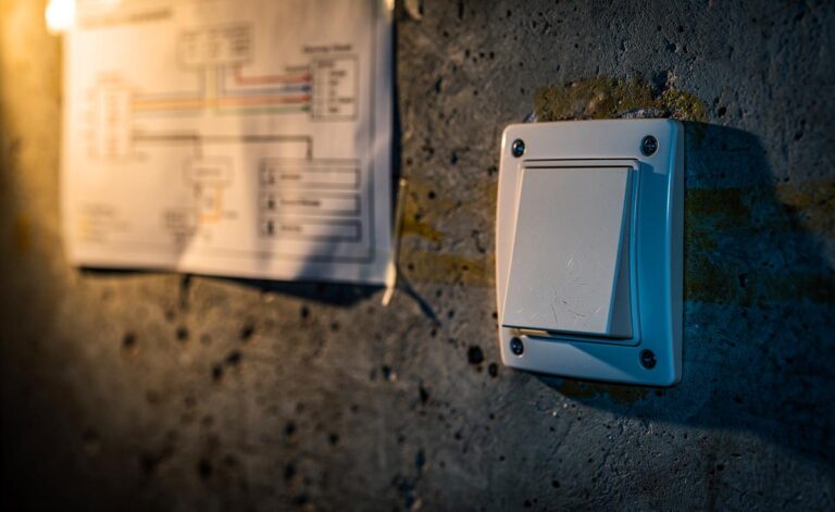 Illustration von einem Lichtschalter an einer Kellerwand und einer schematischen Darstellung der sicheren Stromkreis-Trennung zwischen den Etagen.